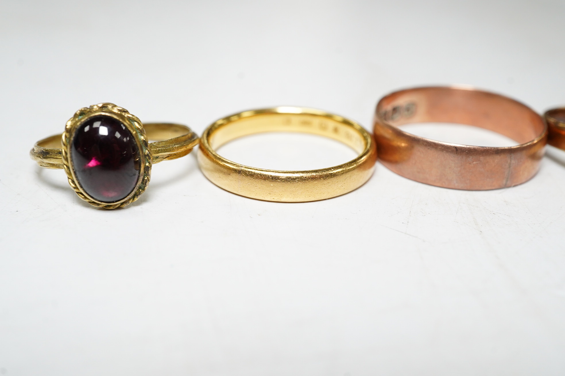 Five assorted rings: a 22ct gold band, size L, 4.2 grams, a 9ct rose gold band, size O, 2.1 grams, a 9ct gold signet ring, size M, 2.1 grams, a red cabochon set yellow metal ring, size I, gross 1.4 grams and a cameo set